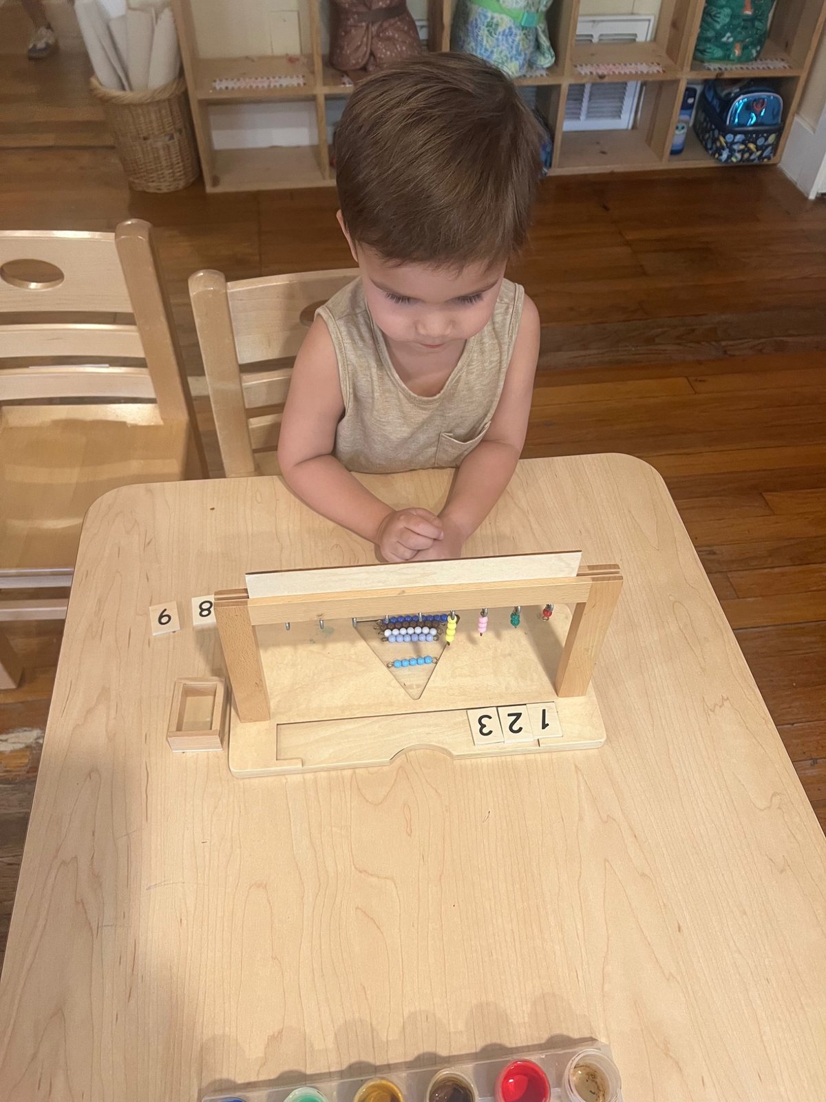 A child concentrating on work with a Montessori bead frame.