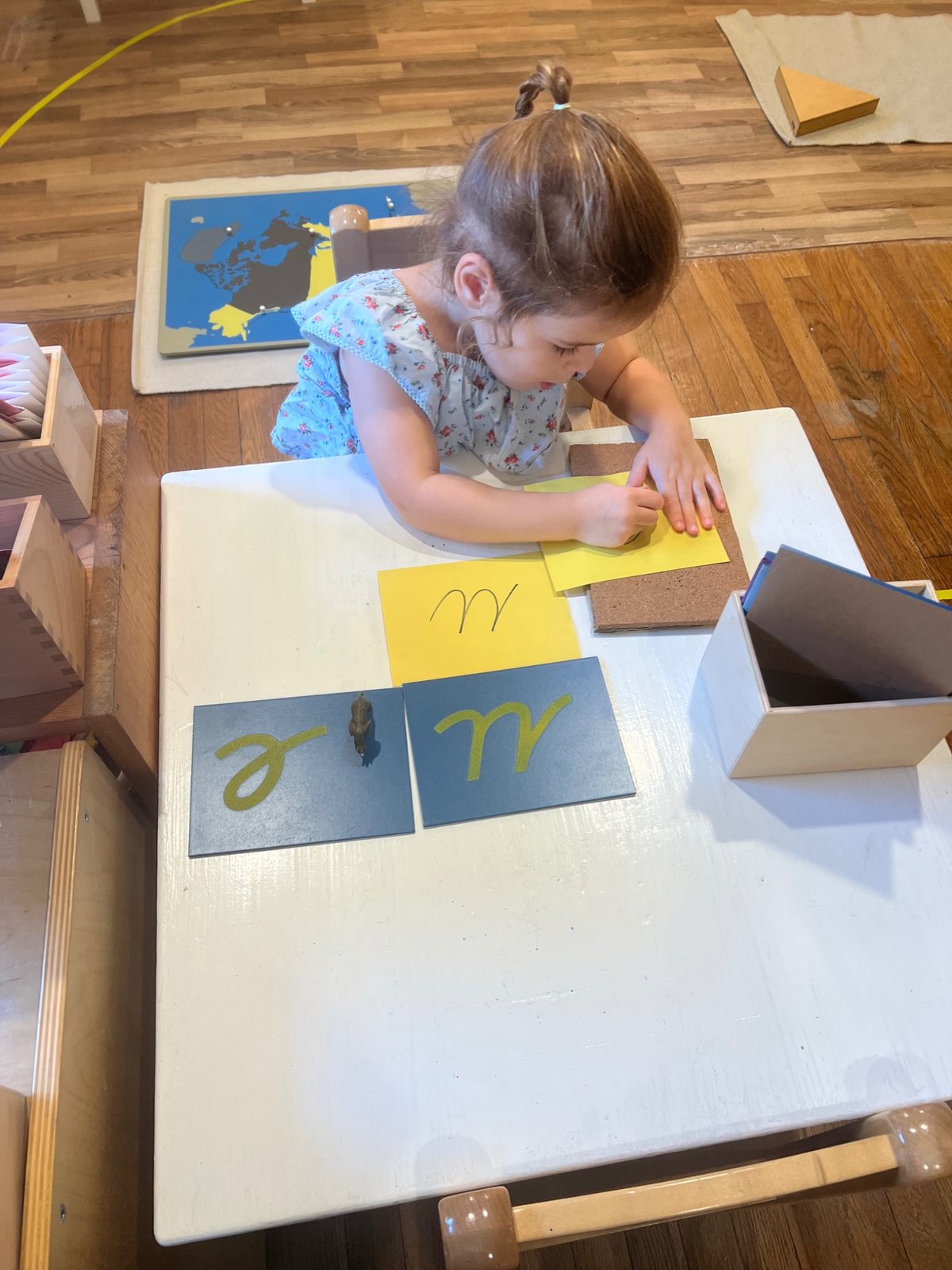 A child practicing a letter with Montessori language materials.