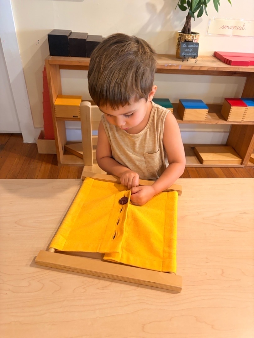 Child practicing an independent Montessori dressing activity at Mi Casita Montessori